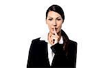 Young business woman gesturing silence sign