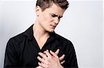 Young man holding his chest with pain