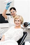 Dentist assistant and female patient looking at camera