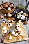 Fresh raw portabello mushrooms with knife on chopping desk omold wood background