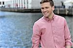 Young smiling man posing casually, outdoors.