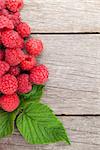 Fresh ripe raspberries on wooden table background with copy space