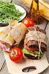 Sandwiches and salad on wooden table. Top view