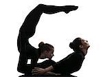 two women contortionist practicing gymnastic yoga in silhouette on white background