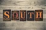 The word "SOUTH" theme written in vintage, ink stained, wooden letterpress type on a wood grained background.