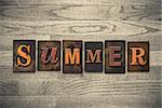 The word "SUMMER" theme written in vintage, ink stained, wooden letterpress type on a wood grained background.