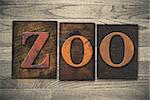 The word "ZOO" theme written in vintage, ink stained, wooden letterpress type on a wood grained background.