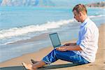 Free businessman working on a sandy beach