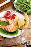 Grilled salmon and whtie wine on wooden table