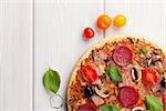 Italian pizza with pepperoni on wooden table. Top view with copy space