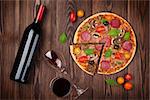 Pizza and red wine on wooden table background. Top view