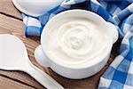 Sour cream in a bowl on wooden table