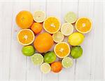 Citrus fruits. Oranges, limes and lemons. Over wooden table background