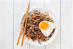 Stir fried char kuey teow with prawns and chopstick over wooden background.