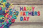 The colorful words "HAPPY FATHERS DAY" on old wooden plank.