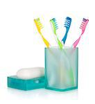 Four multicolored toothbrushes and soap. Isolated on white background