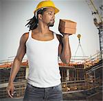 Sexy man mason builds buildings with bricks