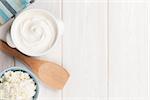 Dairy products on wooden table. Sour cream and curd. Top view with copy space