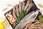 Fresh raw sea food with spices on wooden table background. Top view