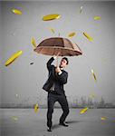 Businessman is protected by a money rain