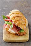 gourmet sandwich croissant with ham and basil
