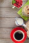 Healthy breakfast with muesli, berries and milk. On wooden table with copy space