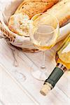 White wine and bread on white wooden table