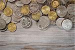 Top view coins on old wooden desk with copy space on bottom.