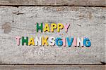 The colorful words "HAPPY THANKSGIVING" made with wooden letters on old wooden board.