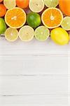 Citrus fruits. Oranges, limes and lemons. Over wooden table background with copy space