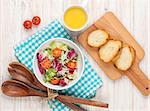 Healthy breakfast with salad, tomatoes and toasts on white wooden table. Top view