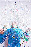 Studio shot of young woman and explosion of confetti