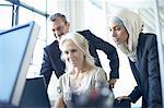 Business team looking at personal computer at office desk