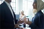 Close up of mature businessman talking to young businesswoman in office