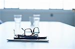 Spectacles, digital tablet and smartphone on conference table