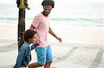 Father and son running hand in hand on Ipanema beach, Rio De Janeiro, Brazil