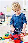 Boy playing with building blocks at home