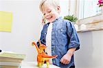 Boy playing with toy dinosaurs at home