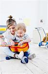 Brother and sister playing toy guitar at home