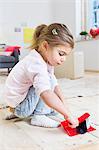 Girl sweeping floor with brush at home