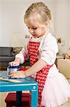 Girl playing mummy in kitchen