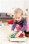 Girl playing with building blocks at home