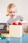 Girl playing with building blocks at home