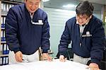 Workers looking at ship plans, GoSeong-gun, South Korea