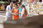 Four tourist friends reading map, Copacabana town, Rio De Janeiro, Brazil