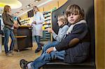 Two brothers waiting whilst mother is talking to pharmacist in a drugstore