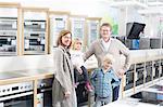 Portrait of family with two children browsing hobs in electronics store