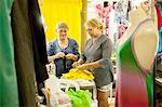 Two seamstresses preparing garments for sewing in workshop