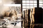 Male cooper working in cooperage with whisky casks