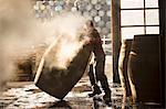 Male cooper working in cooperage with whisky casks